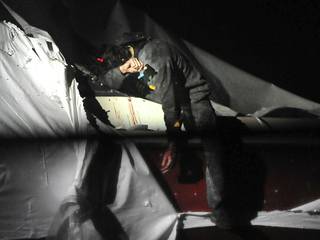 In this Friday, April 19, 2013 photo provided by the Massachusetts State Police, Boston Marathon bombing suspect Dzhokhar Tsarnaev leans over in a boat at the time of his capture by law enforcement authorities in Watertown, Mass. Photos of the Boston Marathon bombing suspect's surrender have been posted on the Boston Magazine website. The additional images, made public Tuesday, Aug. 27, 2013, were among those released to the magazine last month by a state police photographer. (AP Photo/Massachusetts State Police, Sean Murphy)